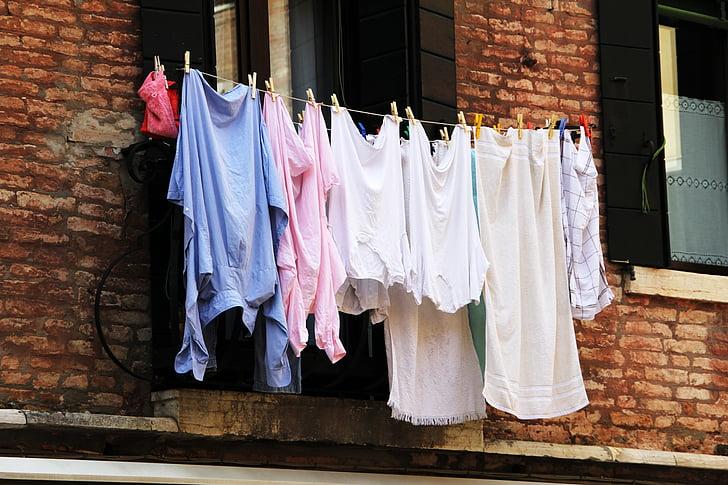 Laundry hanging on a line outside a brick building.