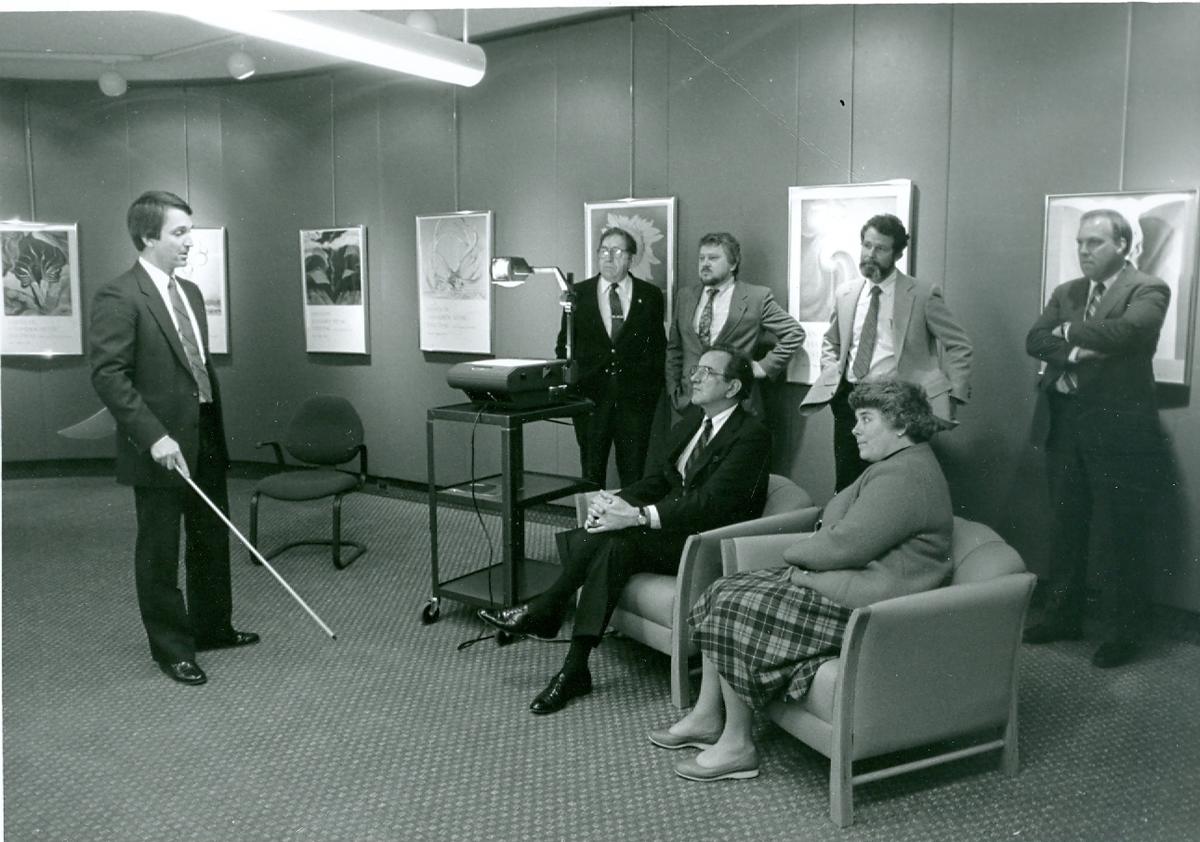 Dated, Black and white image of a small group of men an women in business attire