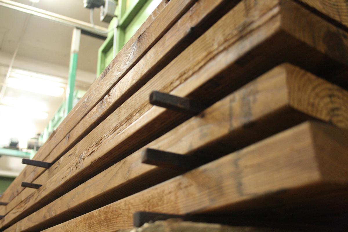 Close image of stacked dark brown lumber